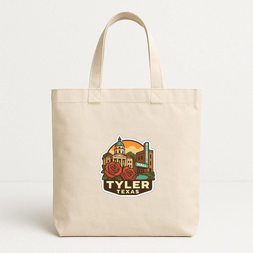 A beige tote bag with a printed design featuring a city skyline and the text "TYLER TEXAS" prominently displayed.