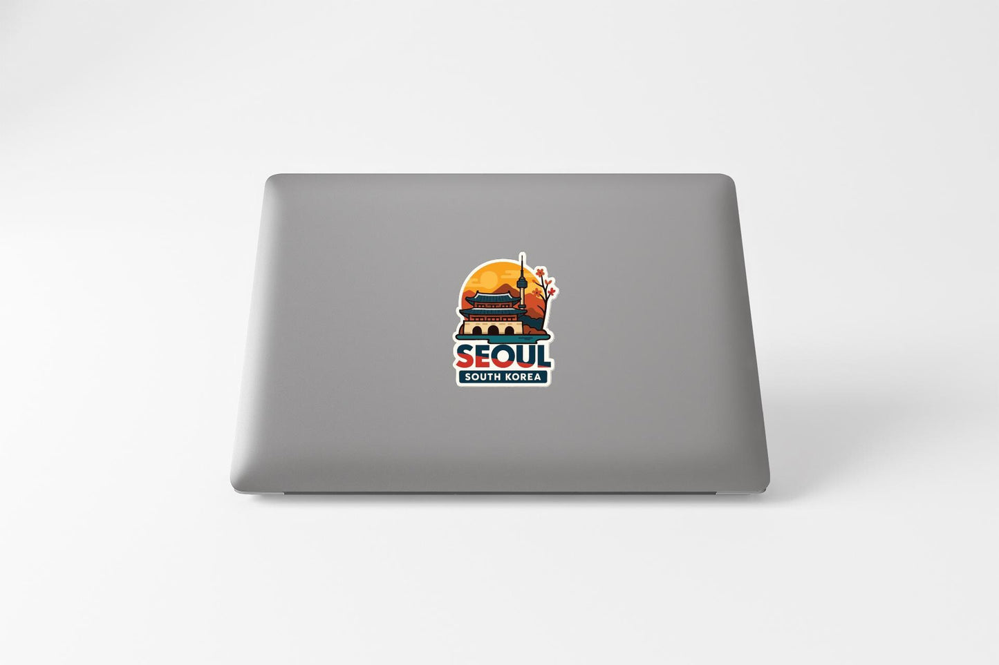 a sticker with a graphic of a building and the text "SEOUL SOUTH KOREA" on the back of a laptop.