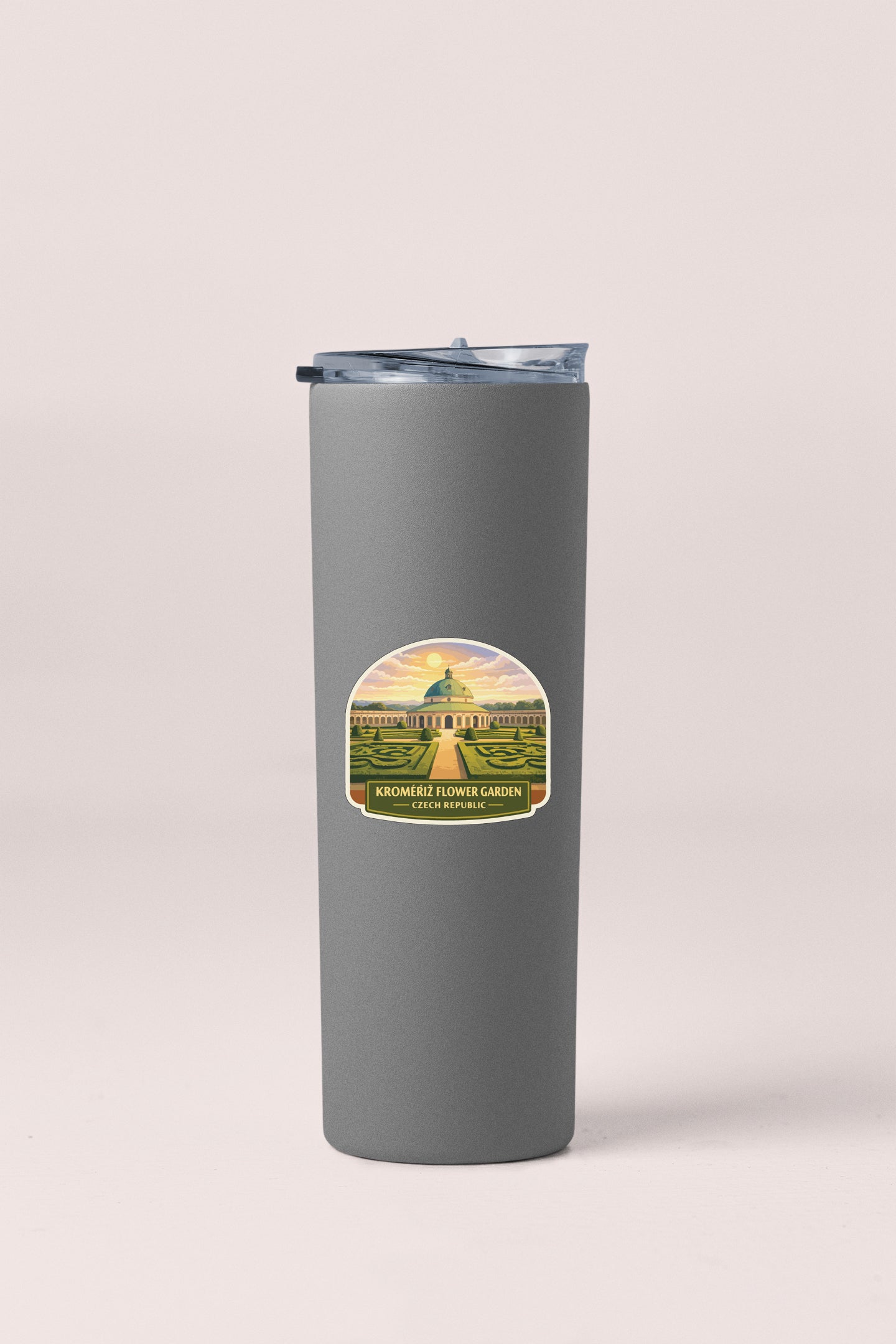 A gray insulated tumbler with a label that features an illustration of a garden and the text "KROMMERFLOWER GARDEN Czech Republic".