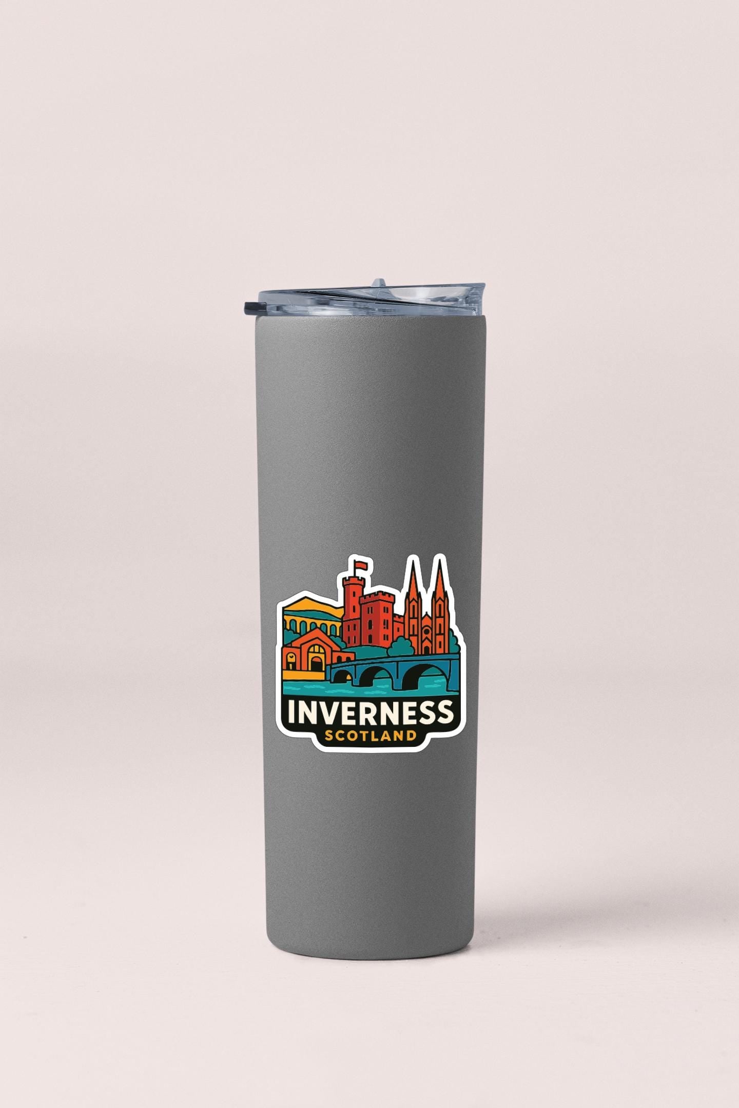 A gray insulated tumbler with a colorful sticker depicting a city skyline.