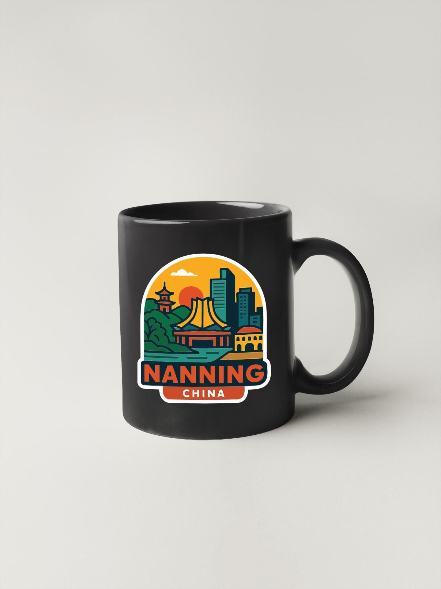 A black coffee mug with a colorful graphic depicting the city of Nanning, China.