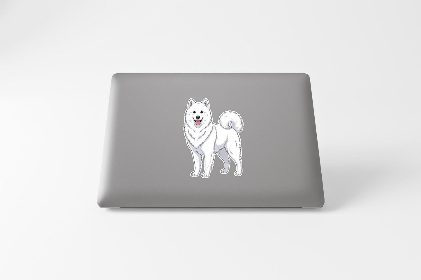 A sticker of a white Samoyed dog on the back of a laptop computer.