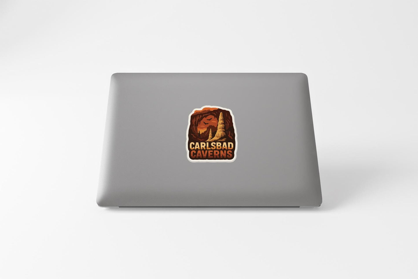 a sticker with the text "CARLSBAD CAVENS" on the back of a laptop.