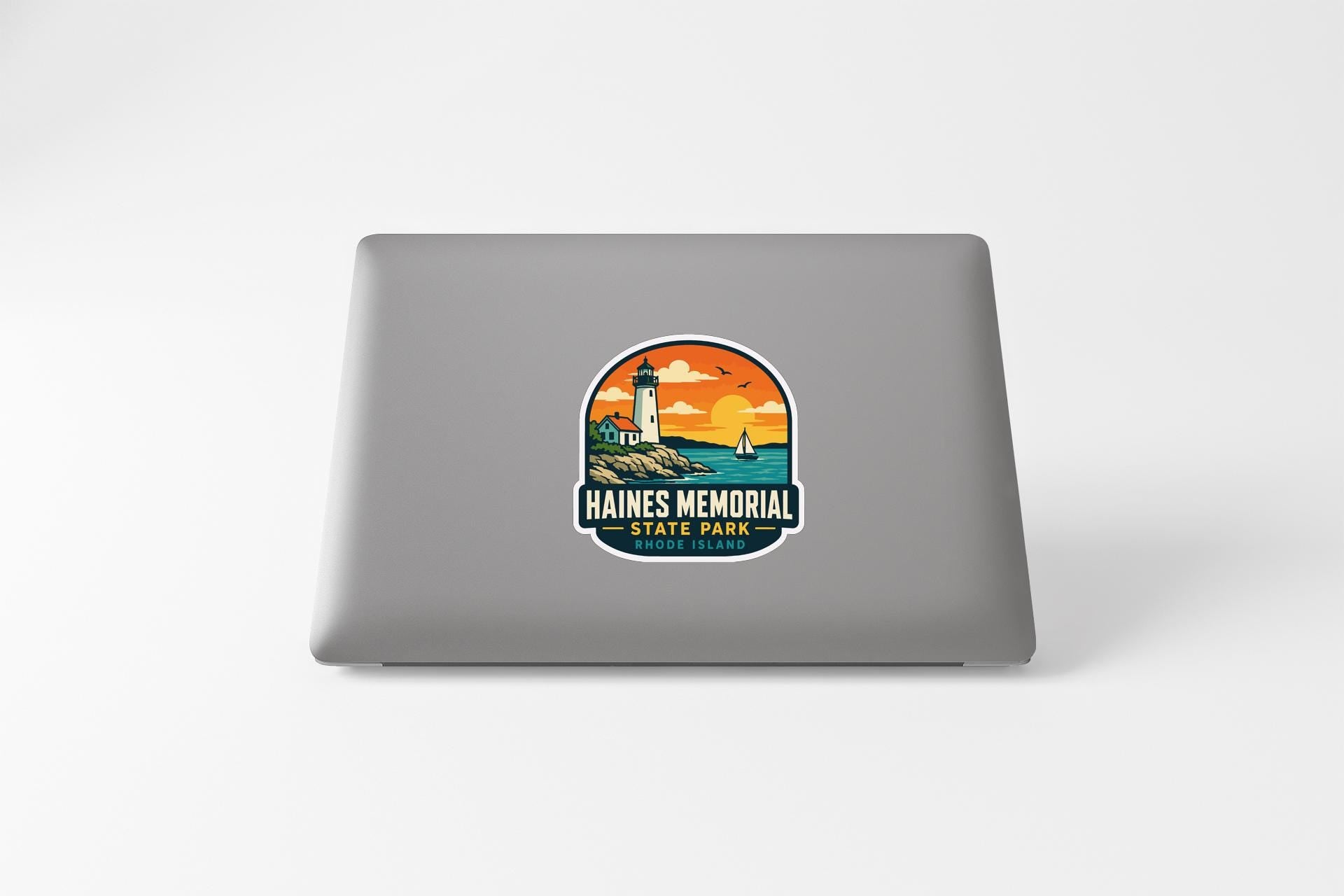a sticker on a laptop that displays a lighthouse and a sunset, with the text "HAINES MEMORIAL STATE PARK" below the illustration.