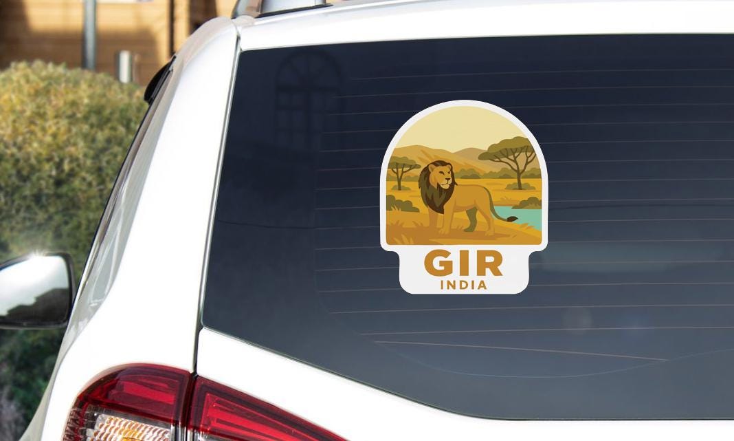 A sticker on the rear window of a car, depicting a lion in a natural setting.