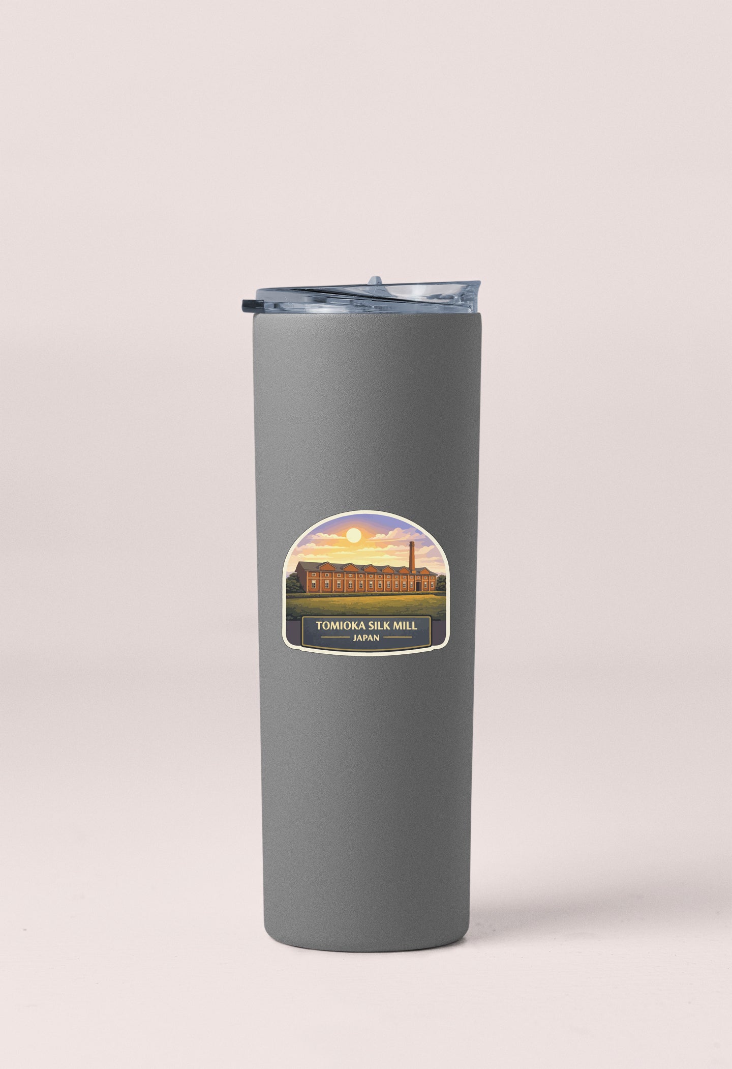 A gray insulated tumbler with a label that says "TOMOKA SILK MILL JAPAN" on it.