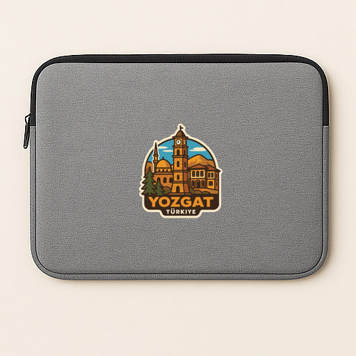 A gray laptop sleeve with a sticker depicting the city of Yozgat, Turkey.