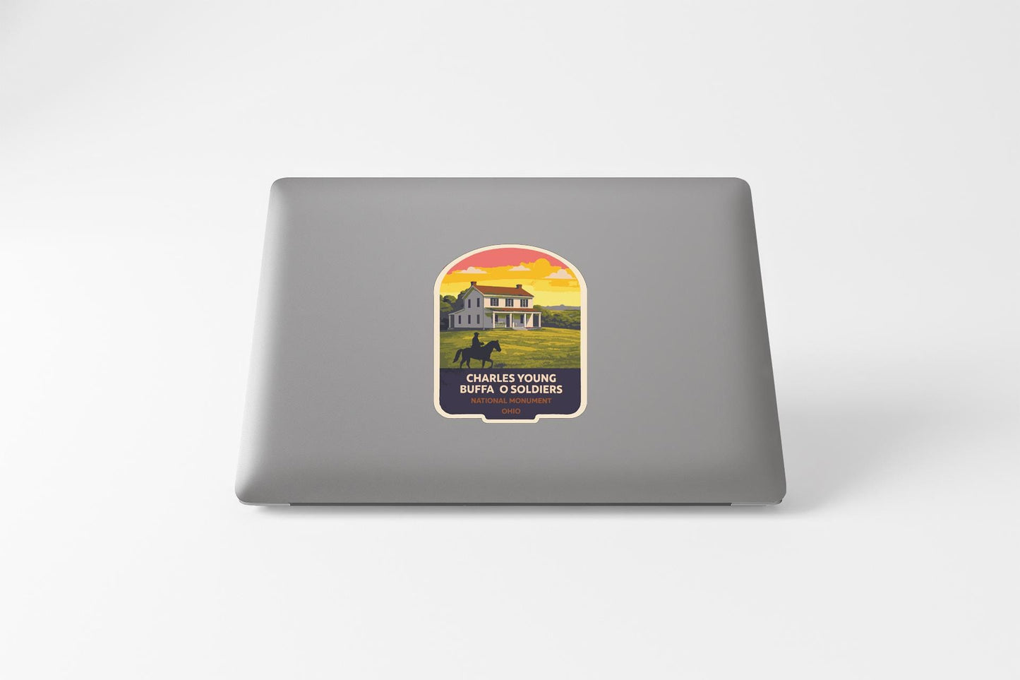 A sticker on the back of a laptop, depicting a house with a horse in a field, and the text "CHARLESTON, WV" and "CHARLESTON SOLDIERS" below it.