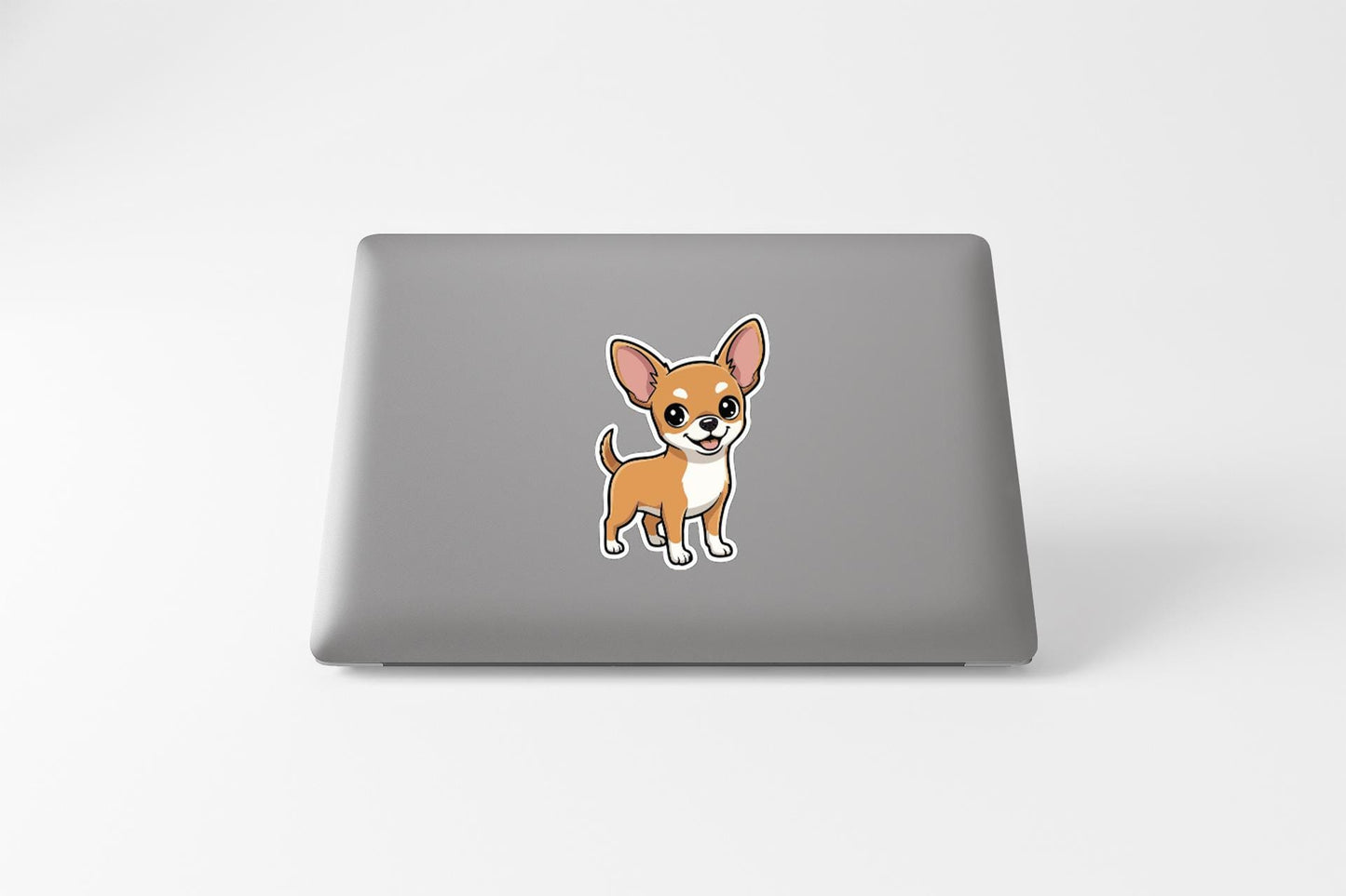 A sticker of a cartoon dog is placed on the back of a laptop computer.