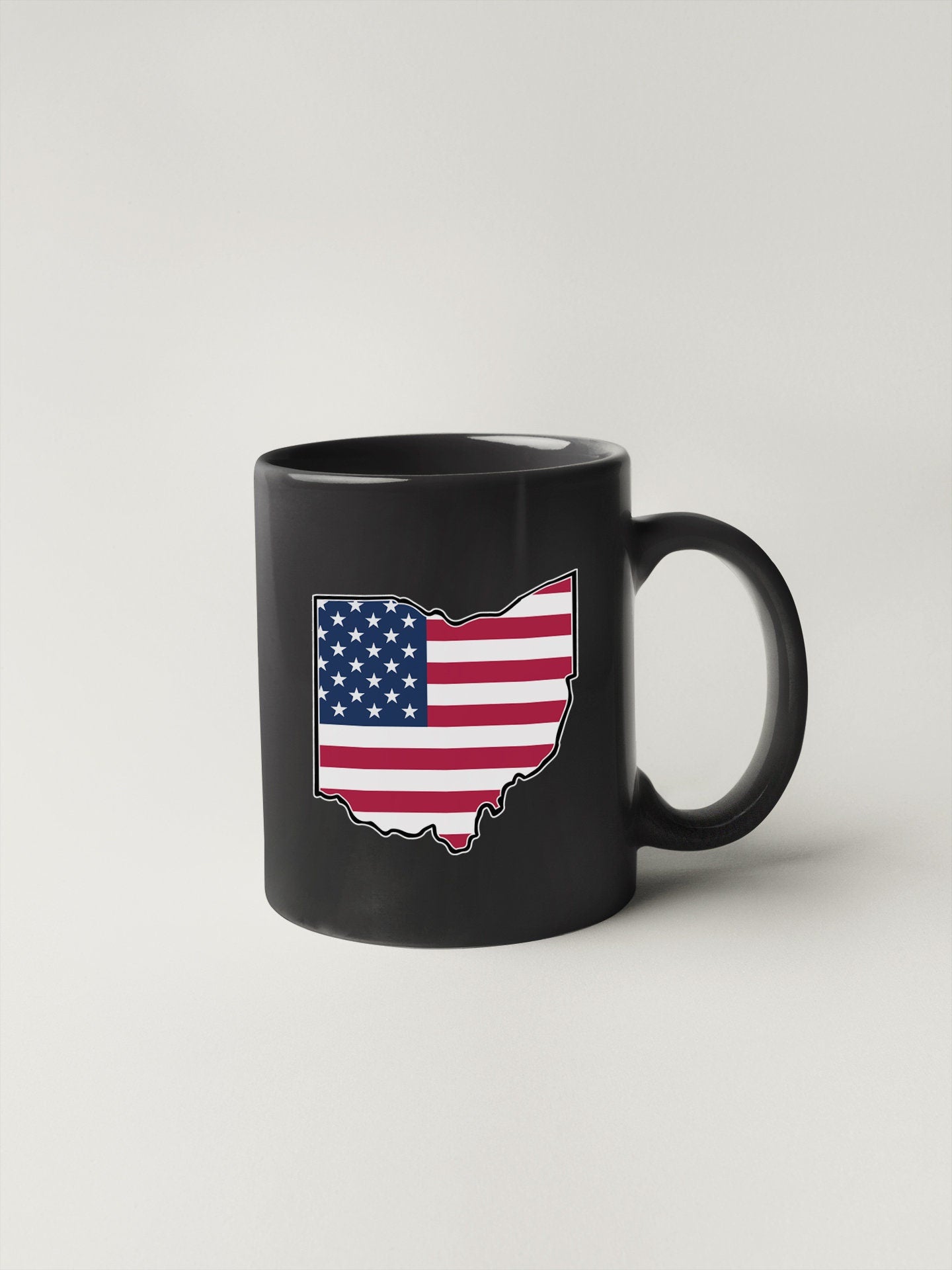 a black coffee mug with an american flag on it