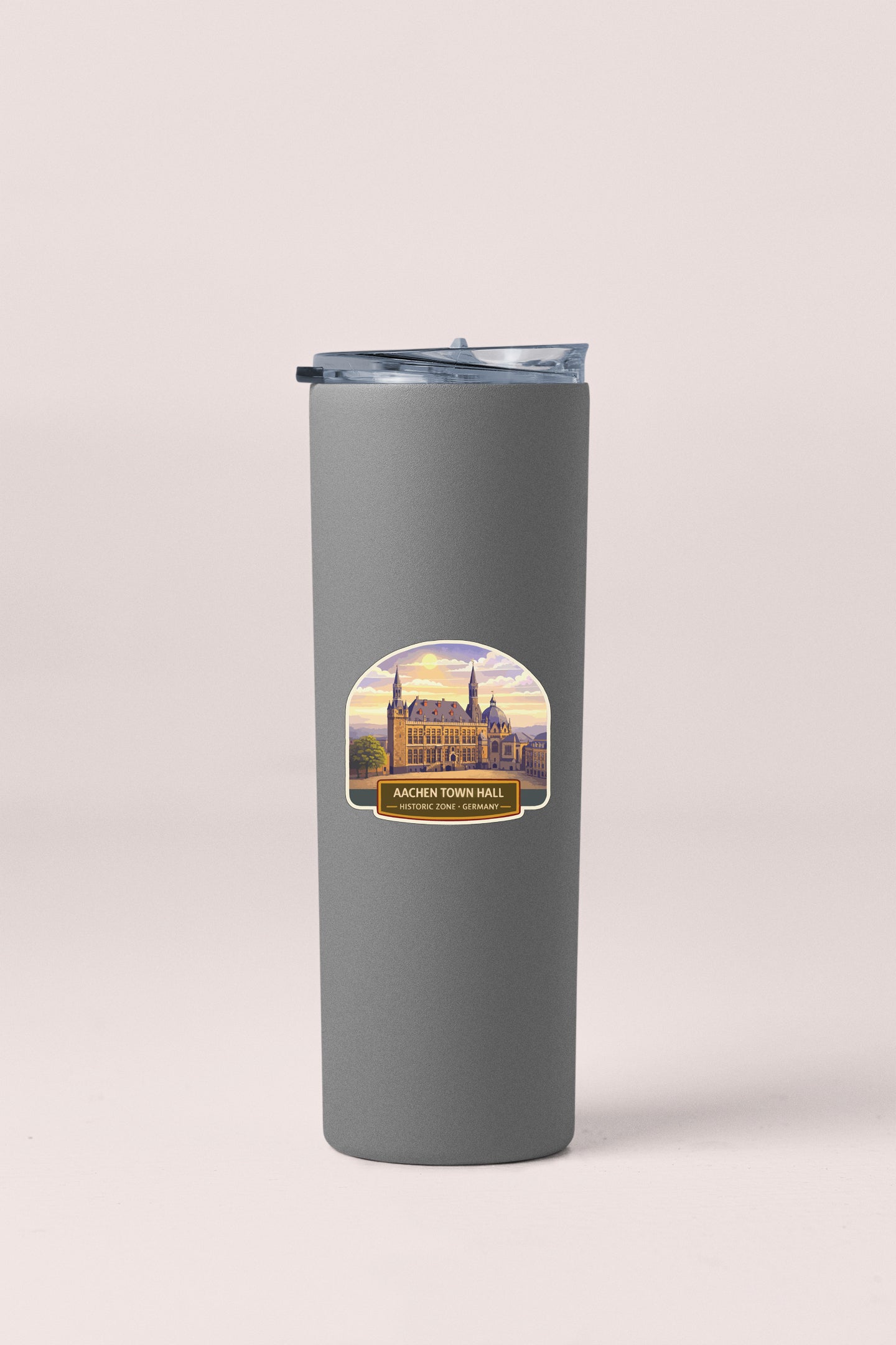 A gray insulated tumbler with a label featuring an illustration of a building and the text "ACCHEN TOWN HALL".