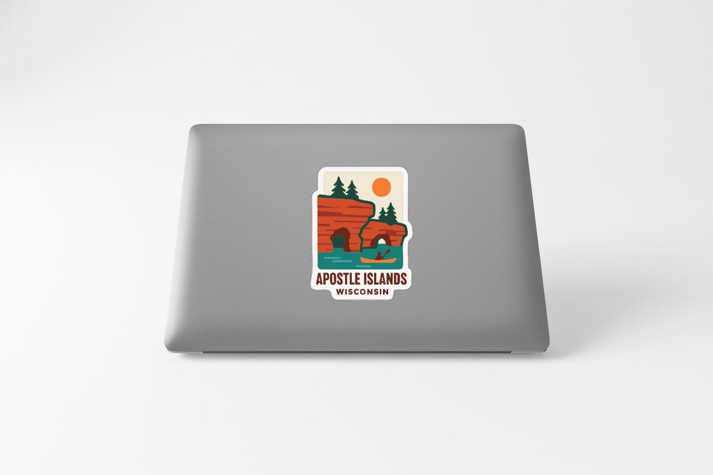 a sticker on the back of a laptop that displays a scenic landscape with a lake, mountains, and a canoe.