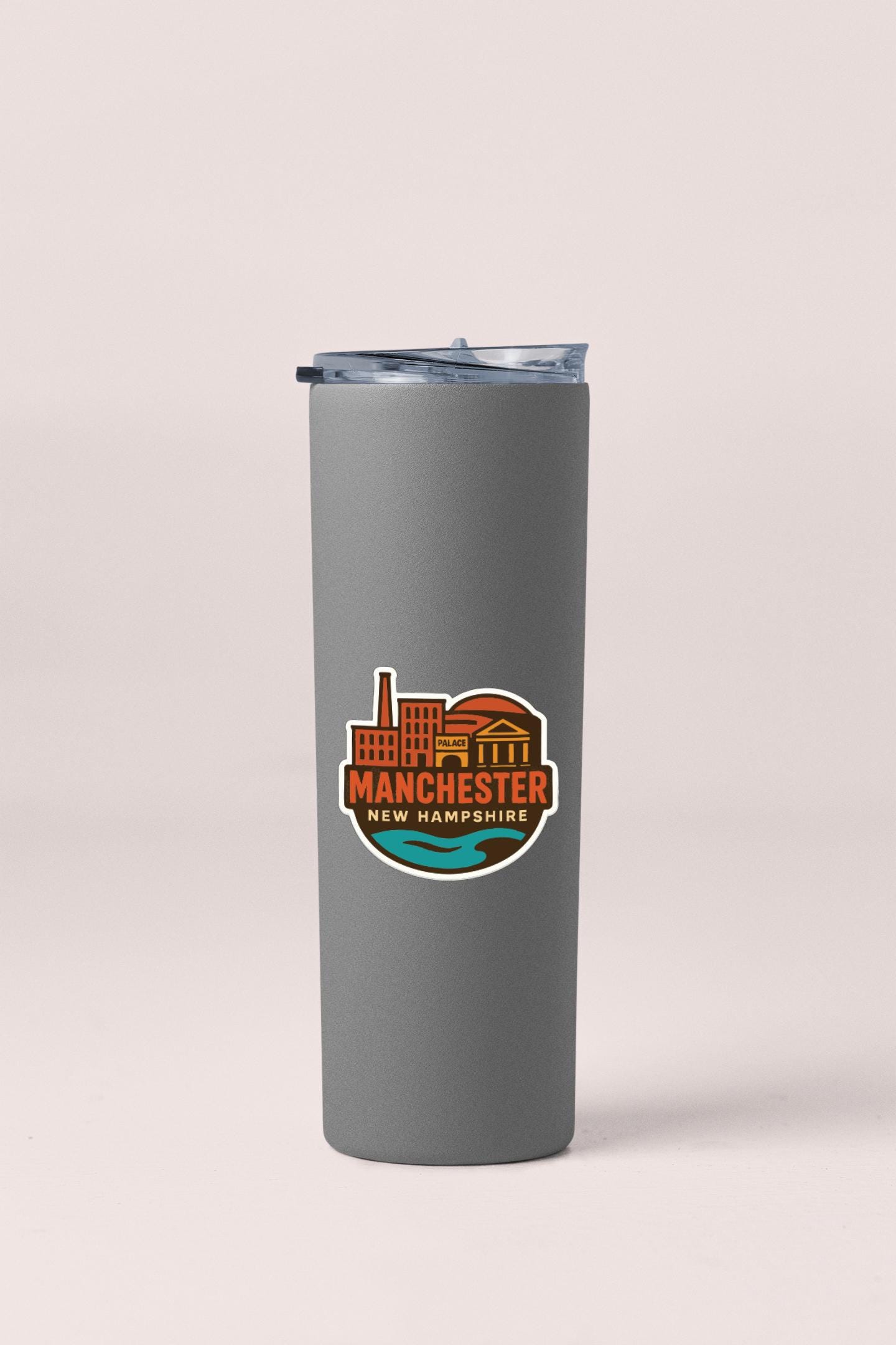 A gray insulated tumbler with a logo depicting the city of Manchester, New Hampshire.