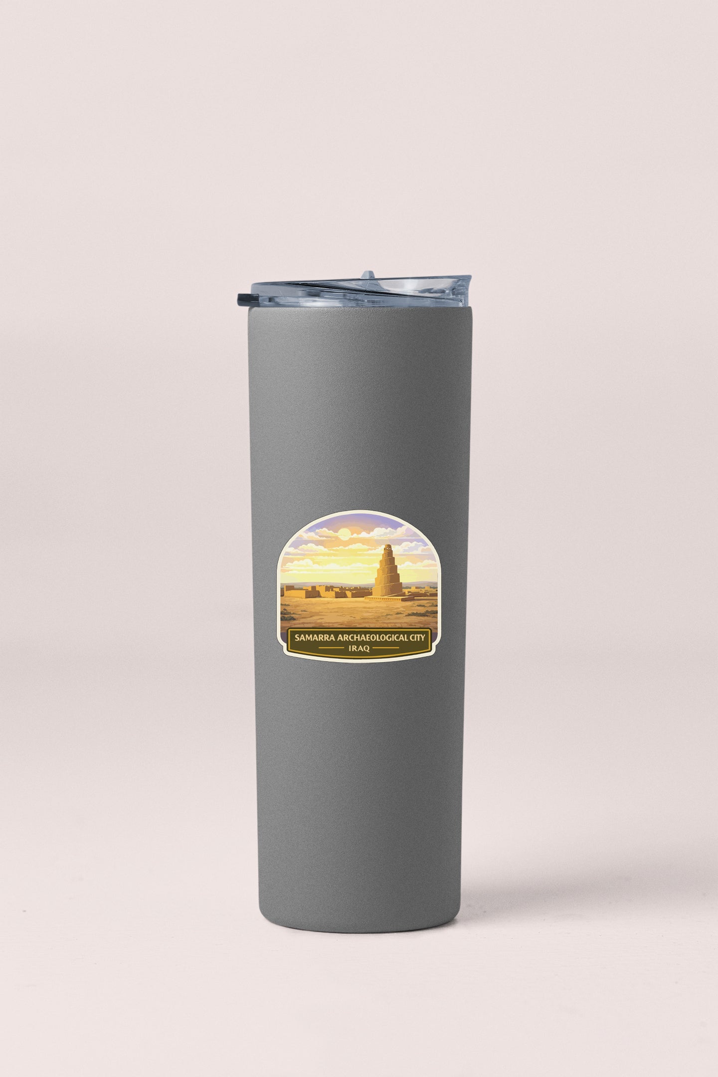 A gray cylindrical container with a lid and a label featuring an image of a desert landscape with a pyramid in the background.