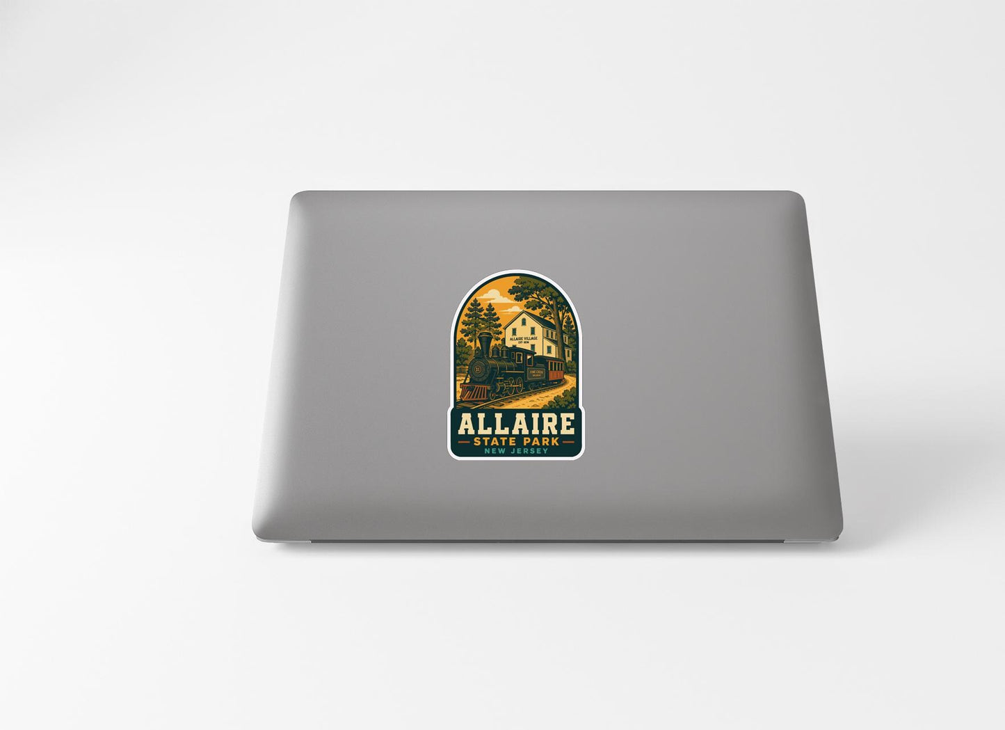 a sticker with a scenic illustration of a train and a house, along with the text "ALLAIRE STATE PARK" printed on it.