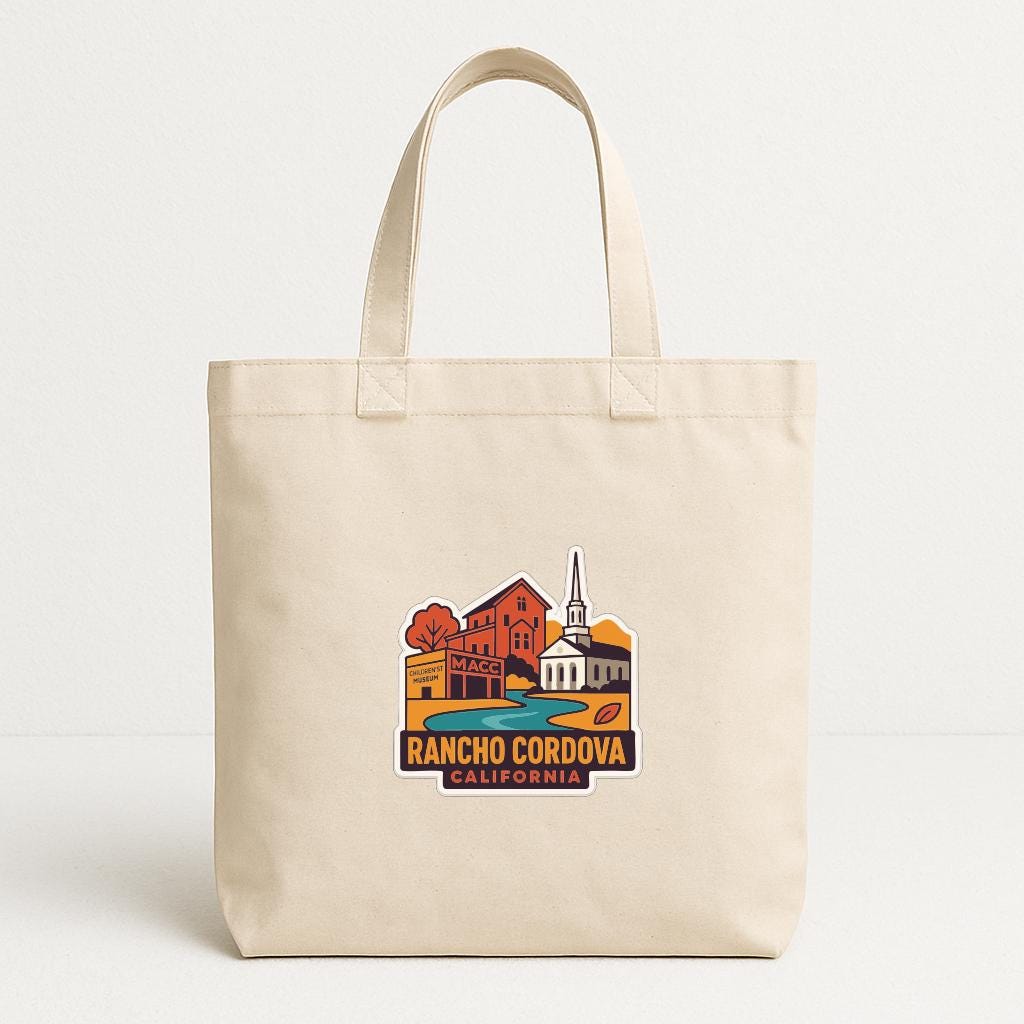 A beige tote bag with a printed design depicting a cityscape and the text "RANCHO CORDOVA, CALIFORNIA".