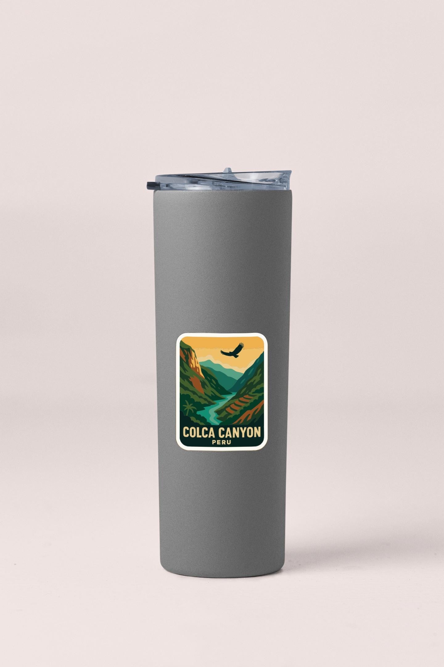 A gray insulated tumbler with a sticker depicting Colca Canyon, a famous national park in Peru.