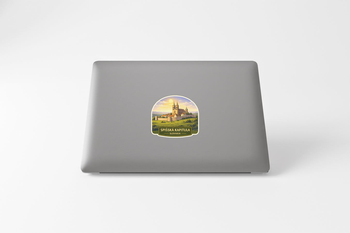 a sticker with a castle on it, placed on the back of a laptop.