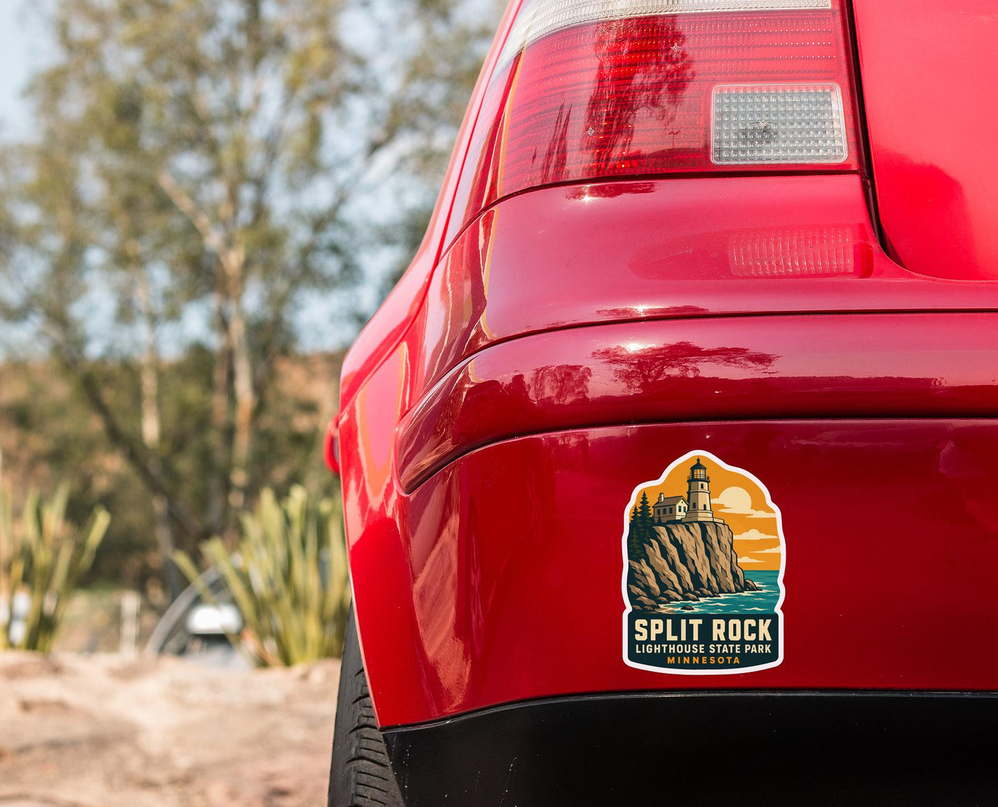 the rear end of a red car with a sticker on the trunk that says "SPLIT ROCK LIGHTHOUSE STATE PARK MINNESOTA".