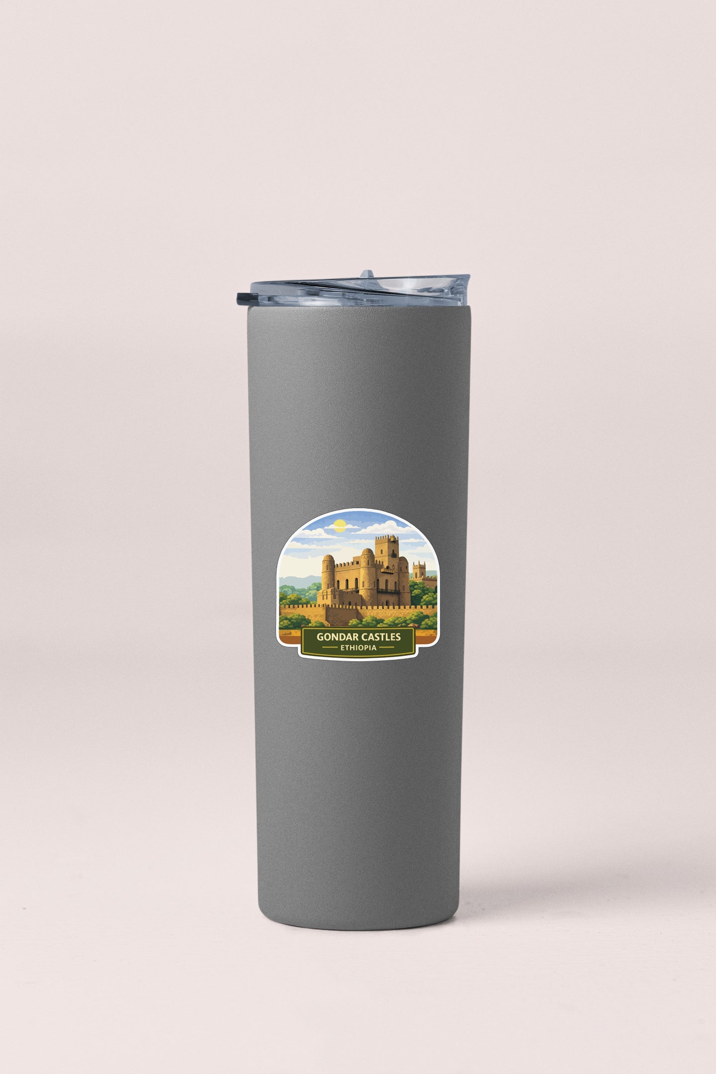 A gray insulated tumbler with a sticker depicting a castle on it.