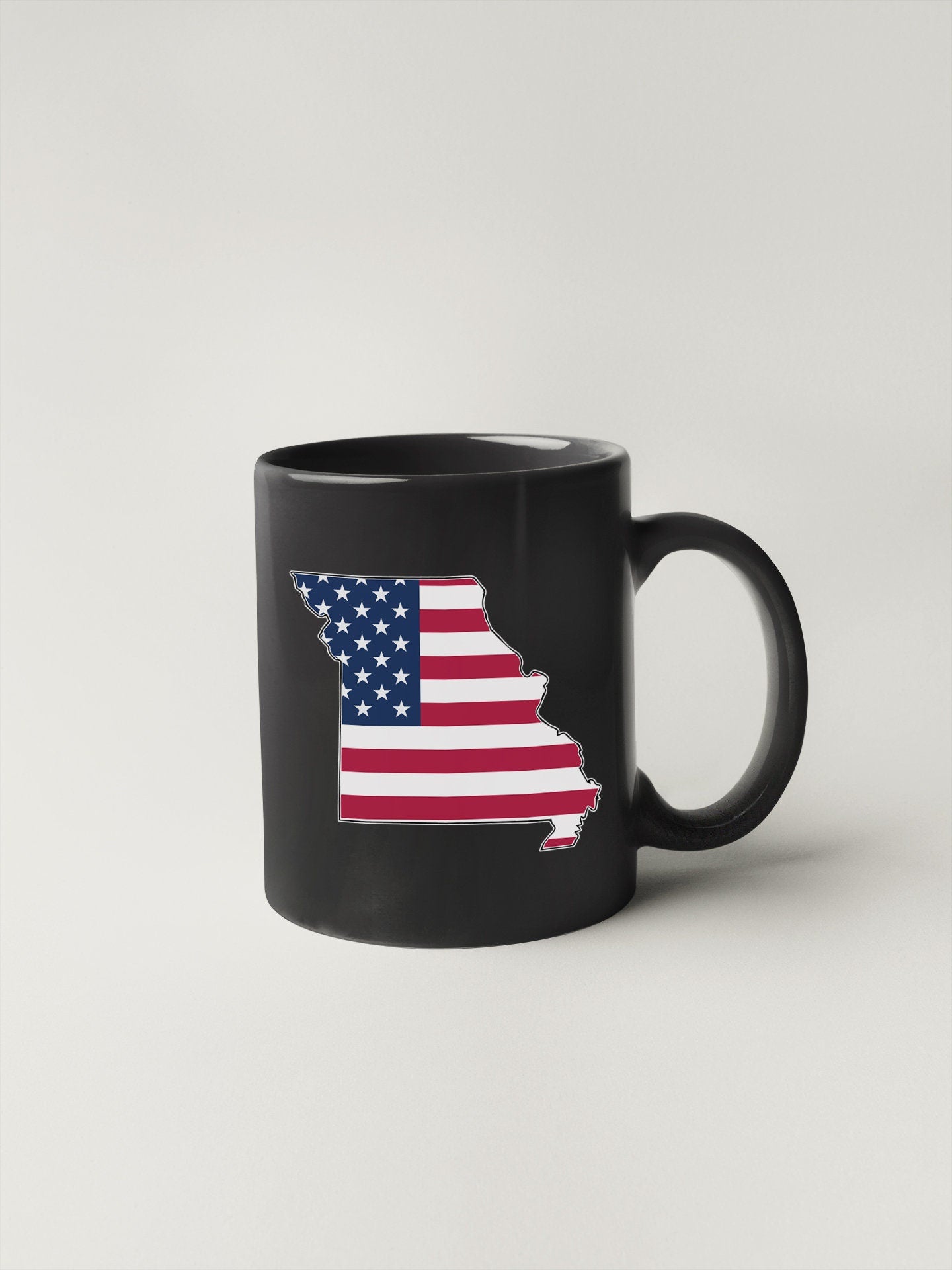a black coffee mug with the state of indiana painted on it