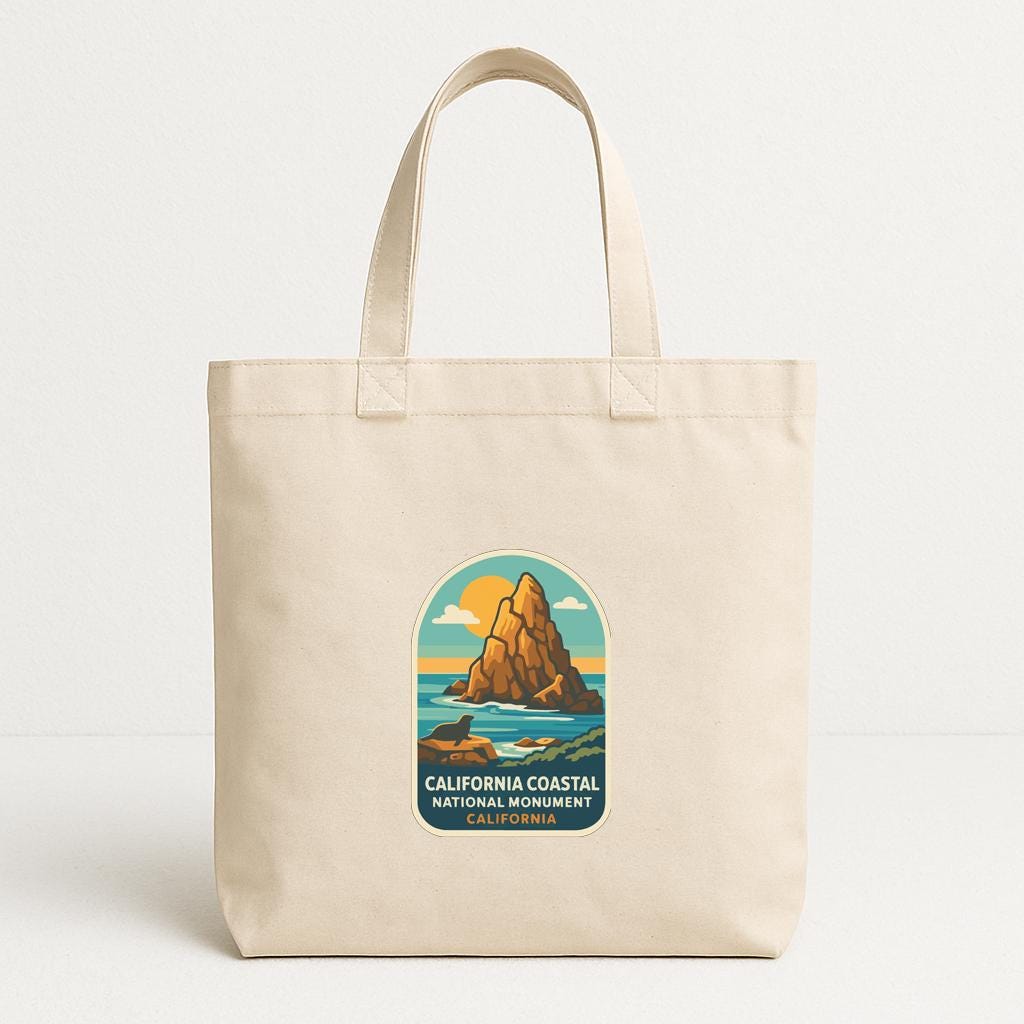 A beige tote bag with a California Coastal National Monument logo printed on it.