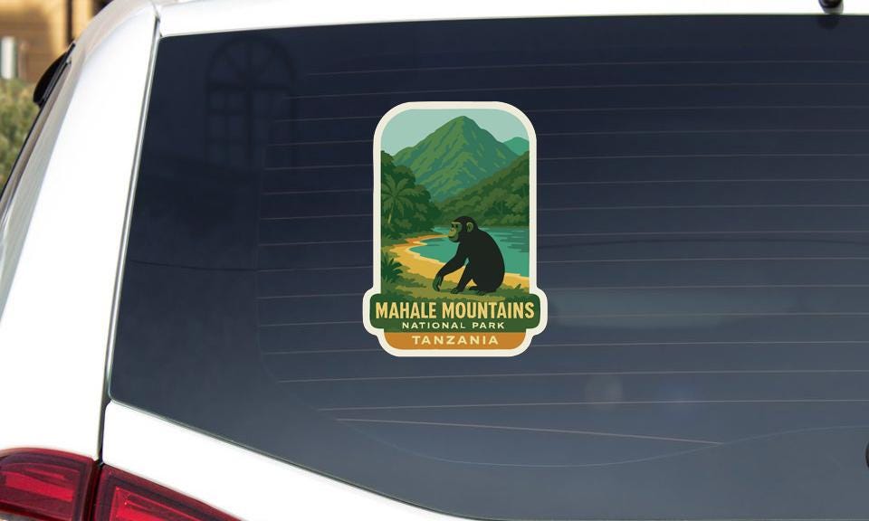 a sticker on the rear window of a vehicle, depicting a scenic landscape with mountains, a river, and a monkey.