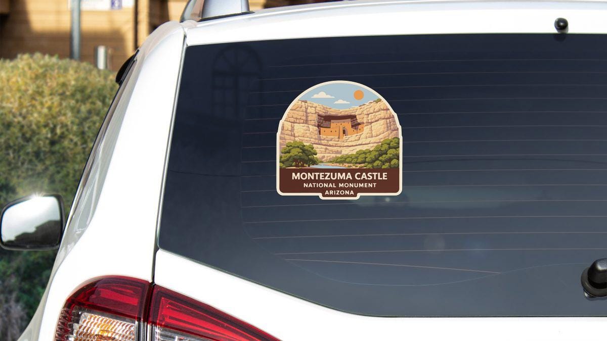 a sticker on the rear window of a car, depicting the Montezuma Castle National Monument in Arizona.