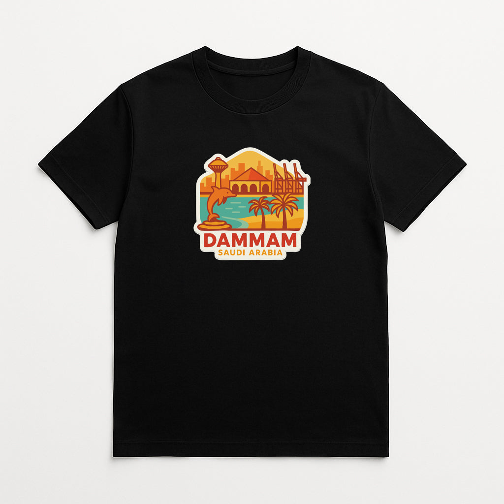 A black t-shirt with a graphic design depicting a cityscape and palm trees, along with the text "DAMMAM SAUDI ARABIA".
