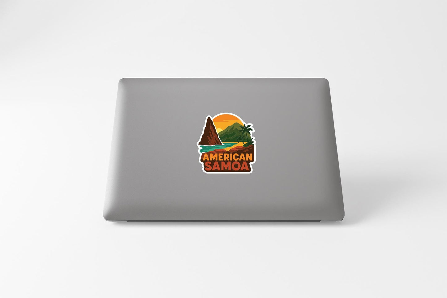 a sticker with a tropical landscape and the text "AMERICAN SAMOA" on the back of a laptop.