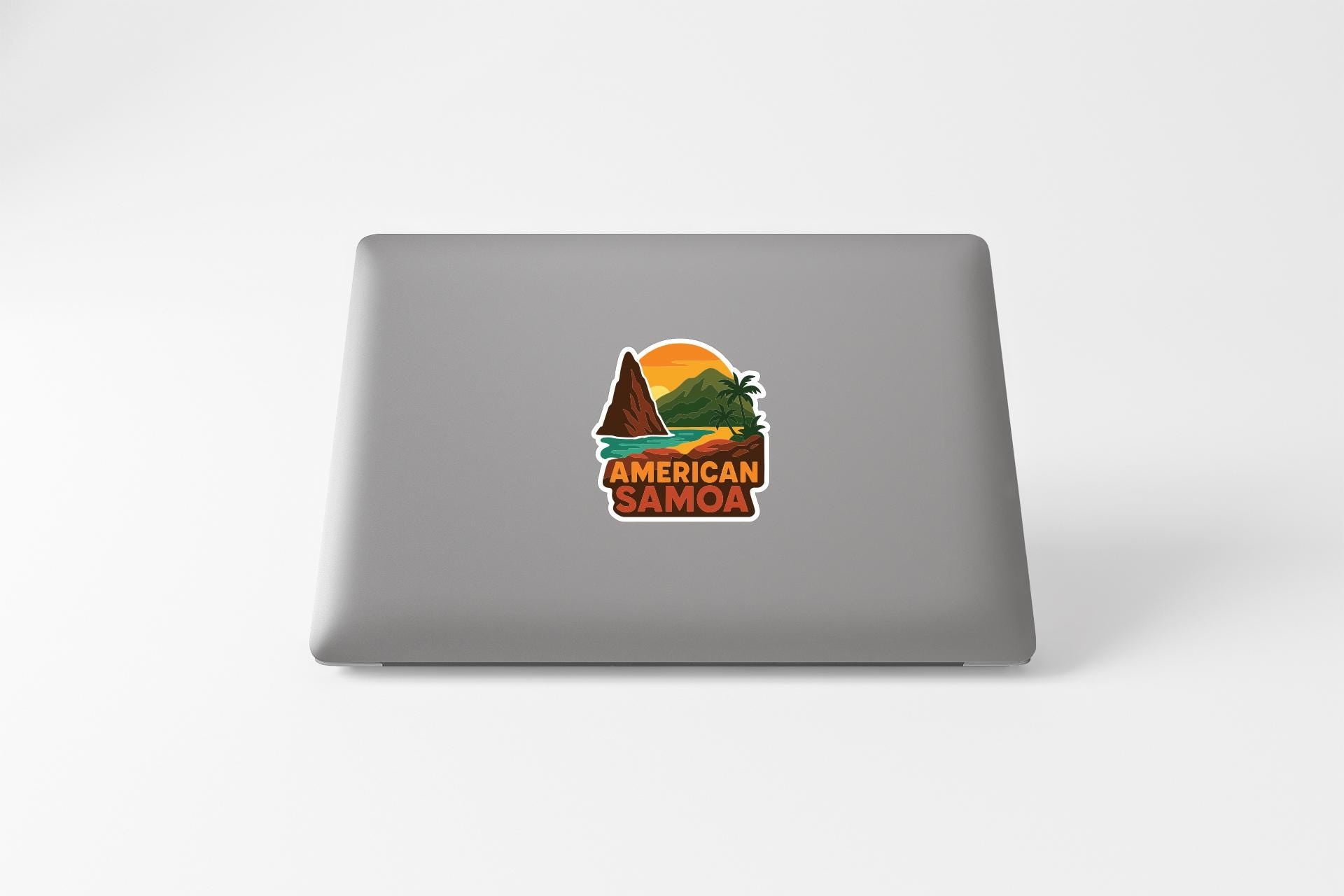 a sticker with a tropical landscape and the text "AMERICAN SAMOA" on the back of a laptop.