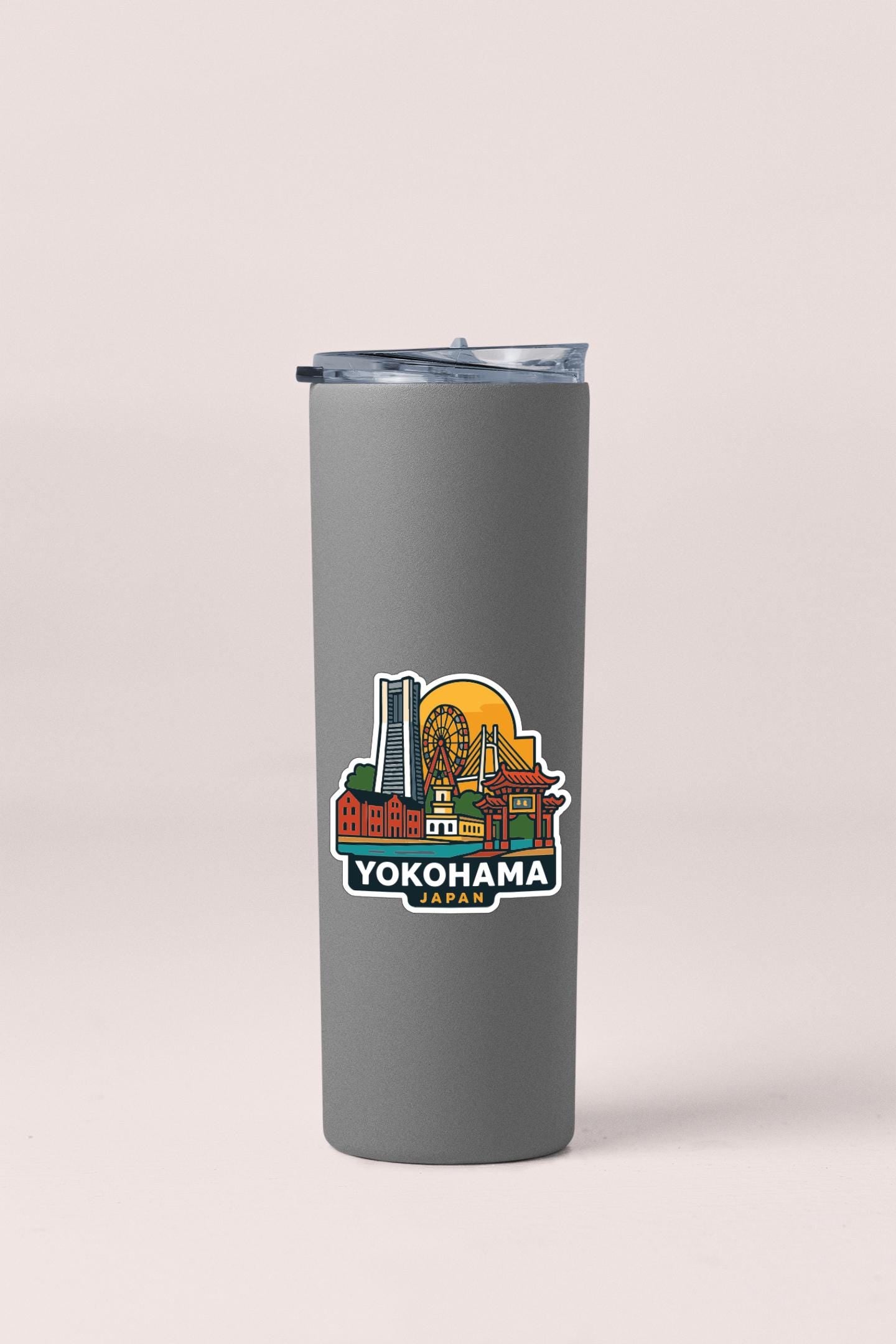 A gray insulated tumbler with a sticker depicting the skyline of Yokohama, Japan.