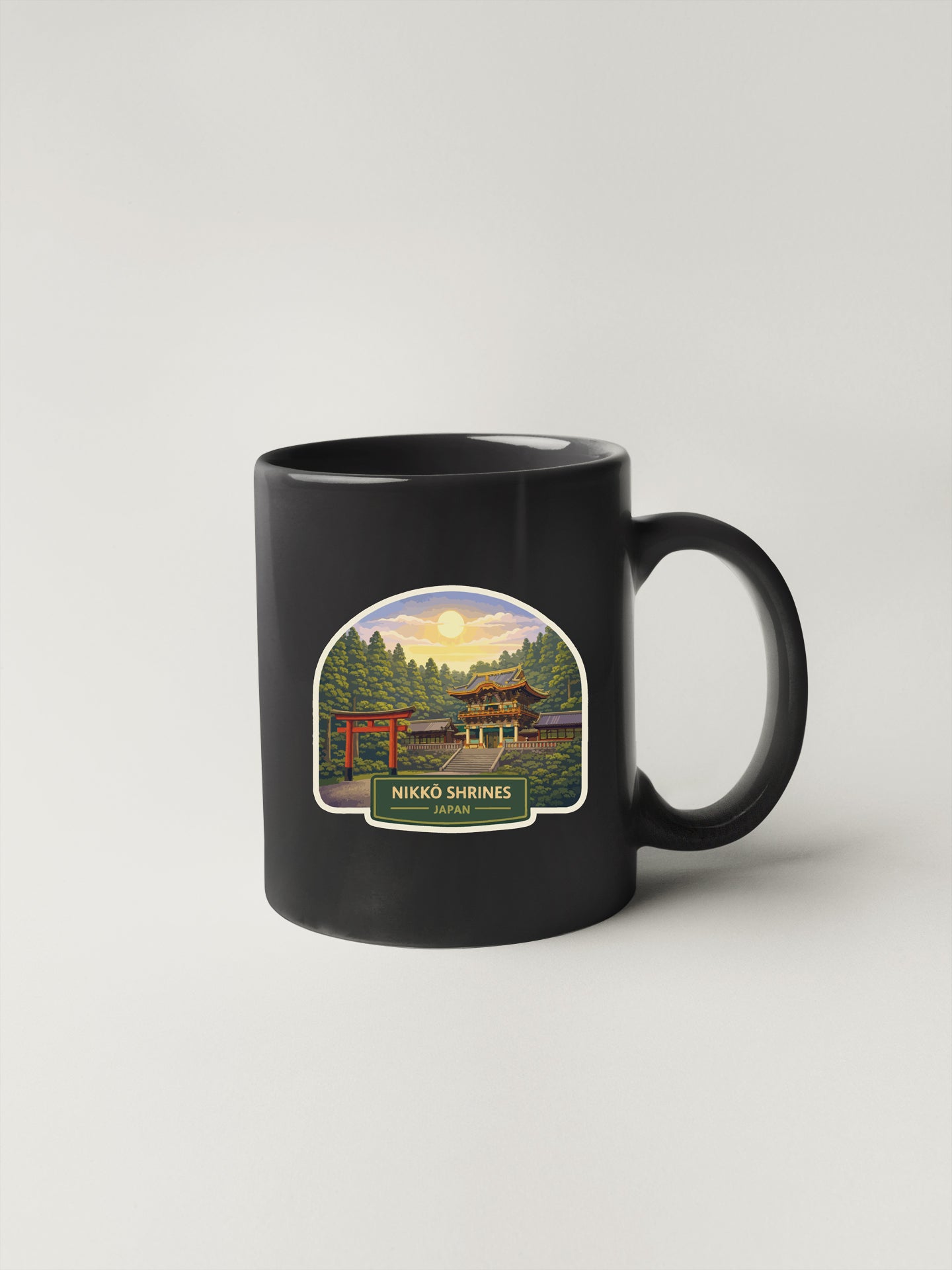 A black coffee mug with a label depicting a scenic landscape featuring a temple, trees, and a sunset.