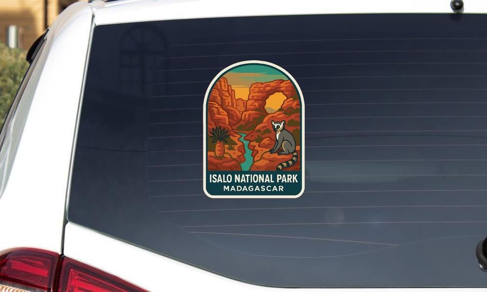 A sticker on the rear window of a car that says "Isalo National Park Madagascar".