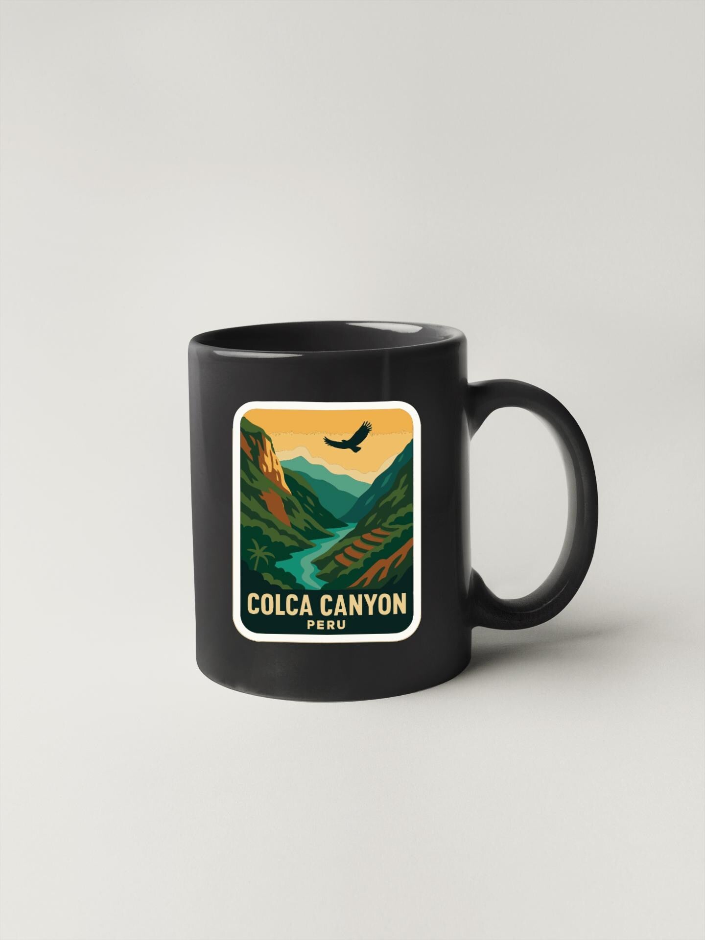 A black coffee mug with a sticker depicting a scenic landscape of Colca Canyon, Peru.