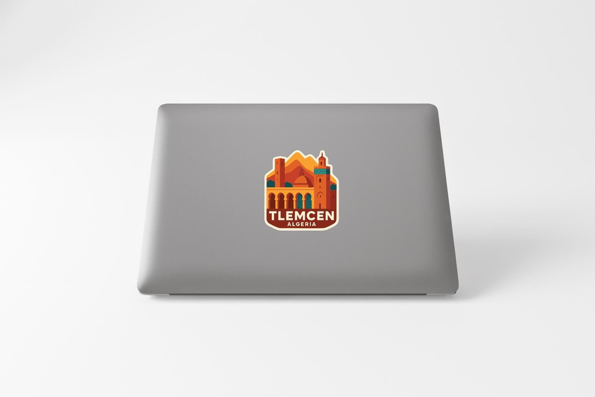 a sticker with a graphic of a building and mountains, along with the text "TLEMCEEN ALGORIA".