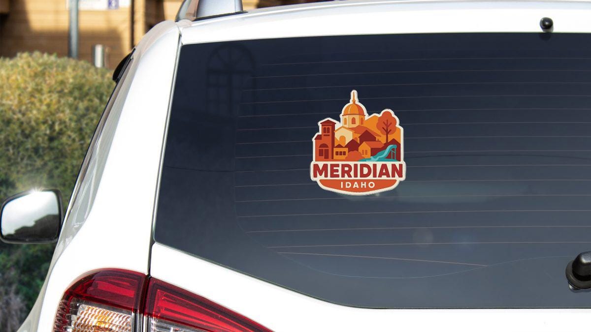 A sticker on the rear window of a white car, displaying the name "MERIDIAN IDAHO".