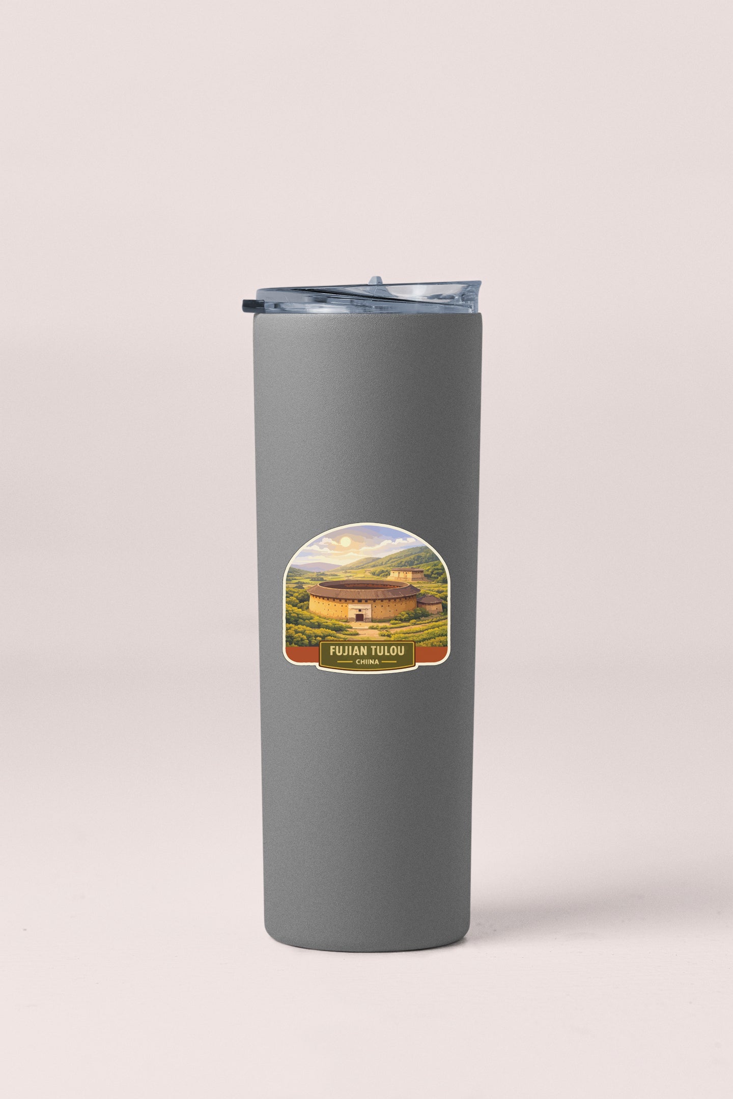 A gray insulated tumbler with a label featuring a scenic landscape.