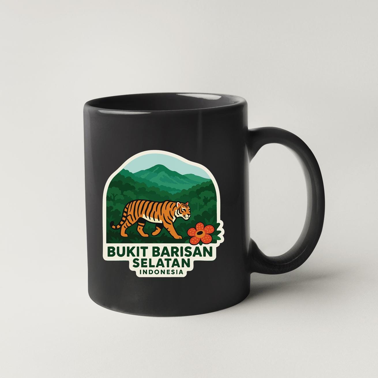 A black coffee mug with a graphic design depicting a tiger walking through a forest landscape, along with the text "BUKIT BARISAN SELATAN INDONESIA".