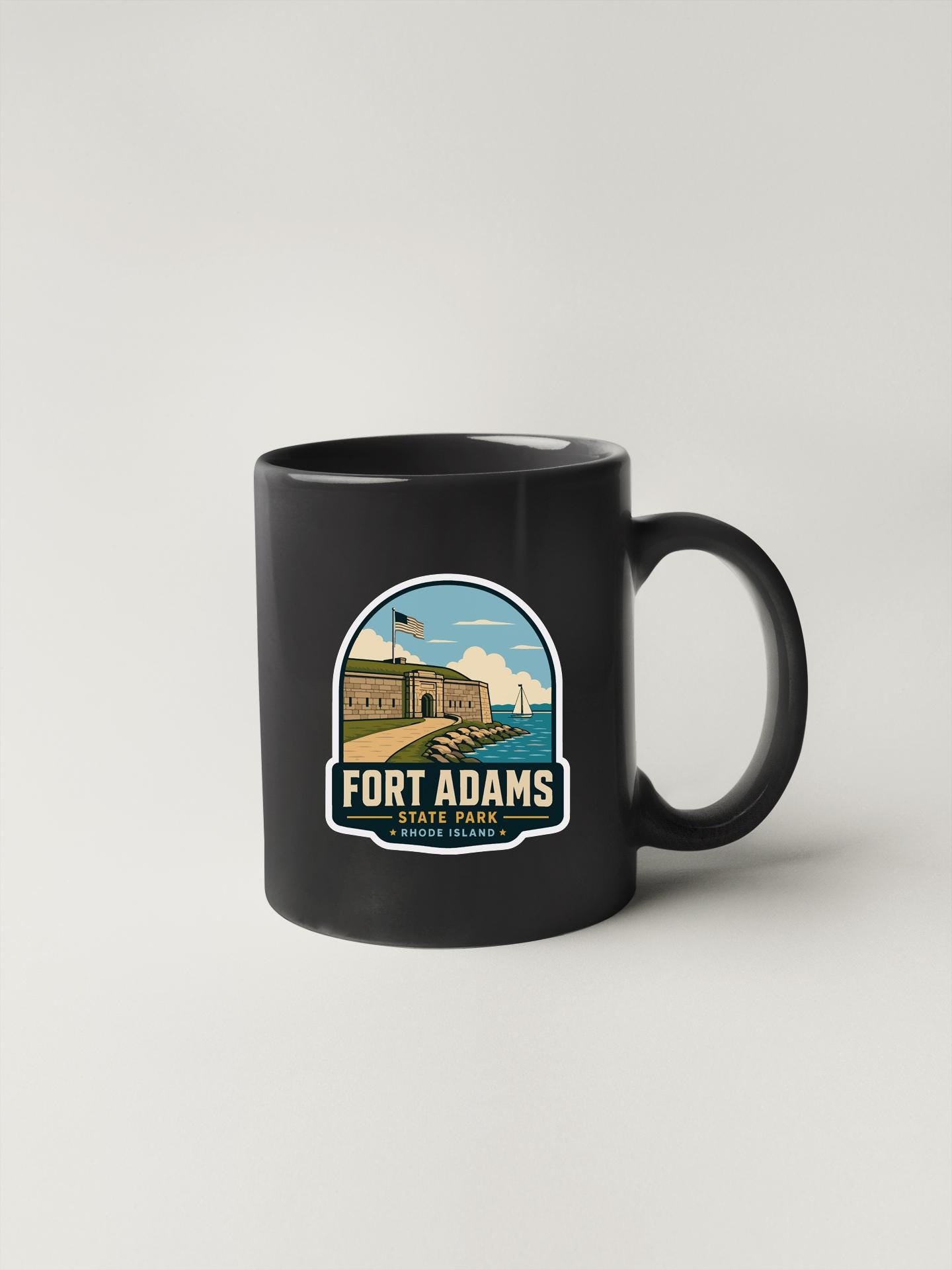 A black coffee mug with a graphic design depicting Fort Adams State Park in Rhode Island.