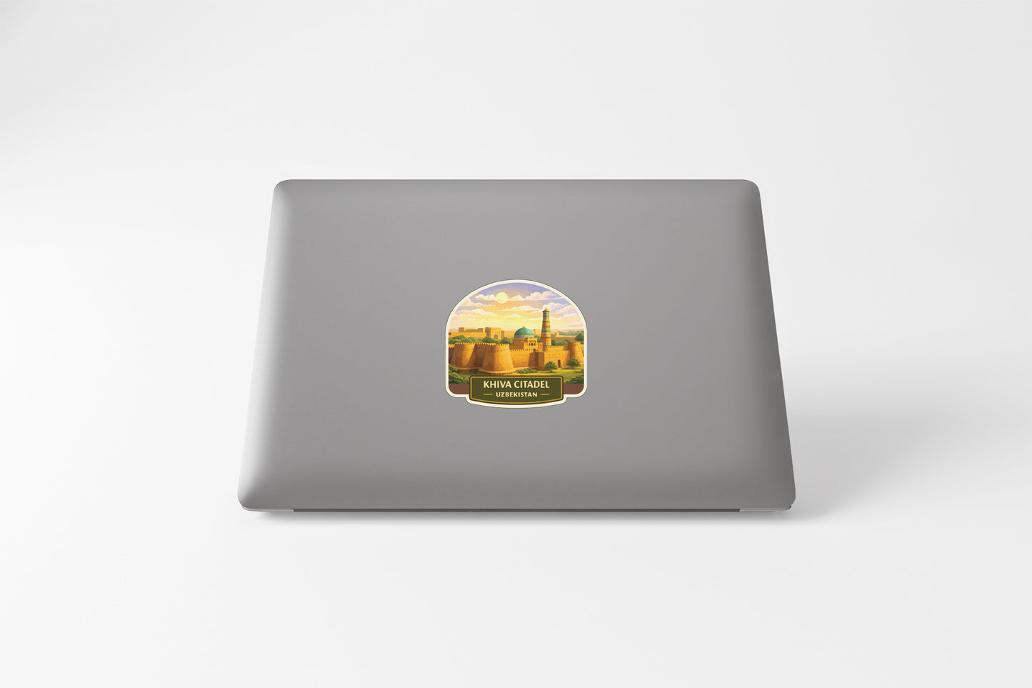 A sticker depicting a cityscape on the back of a laptop computer.