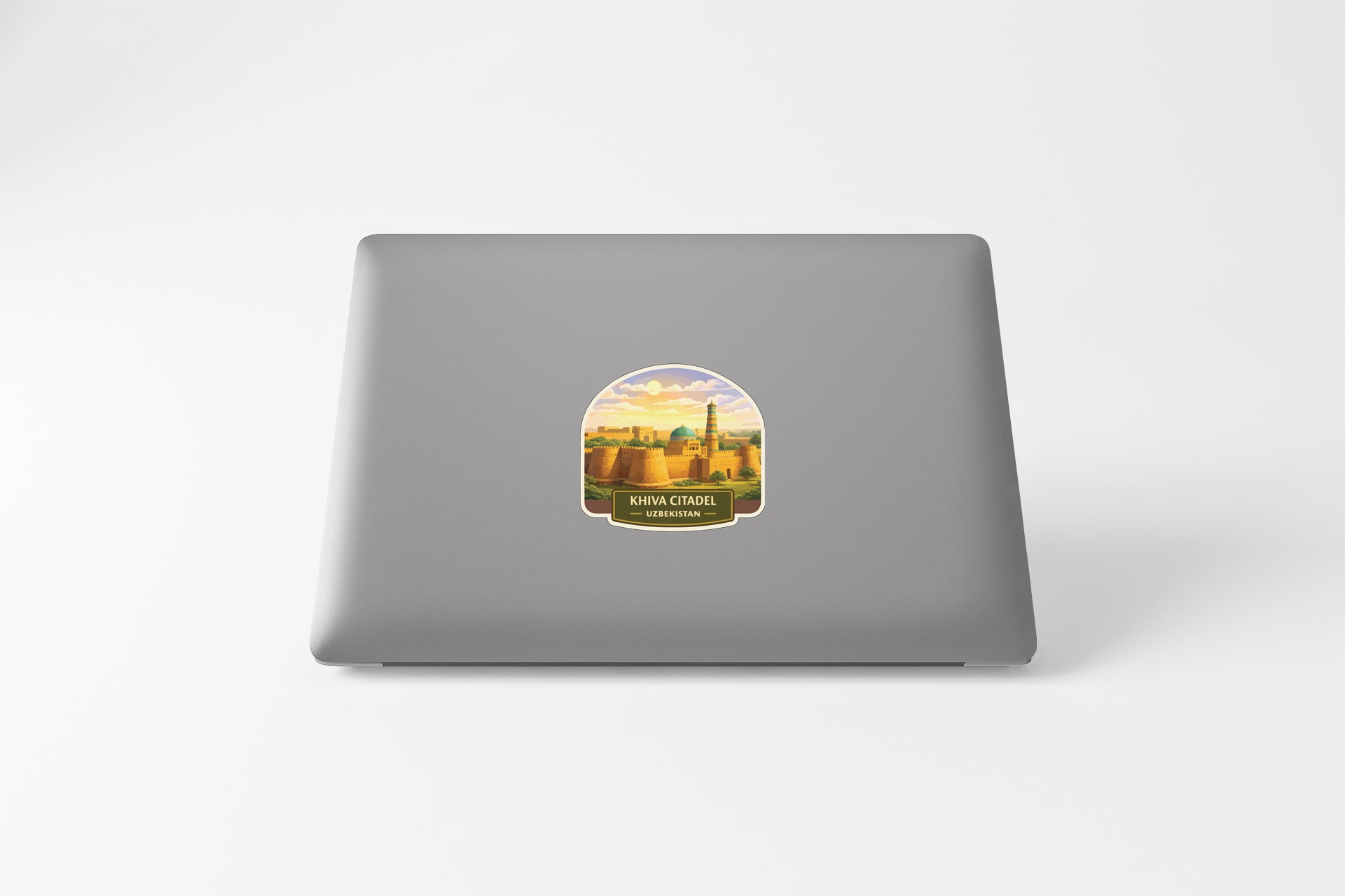 A sticker depicting a cityscape on the back of a laptop computer.