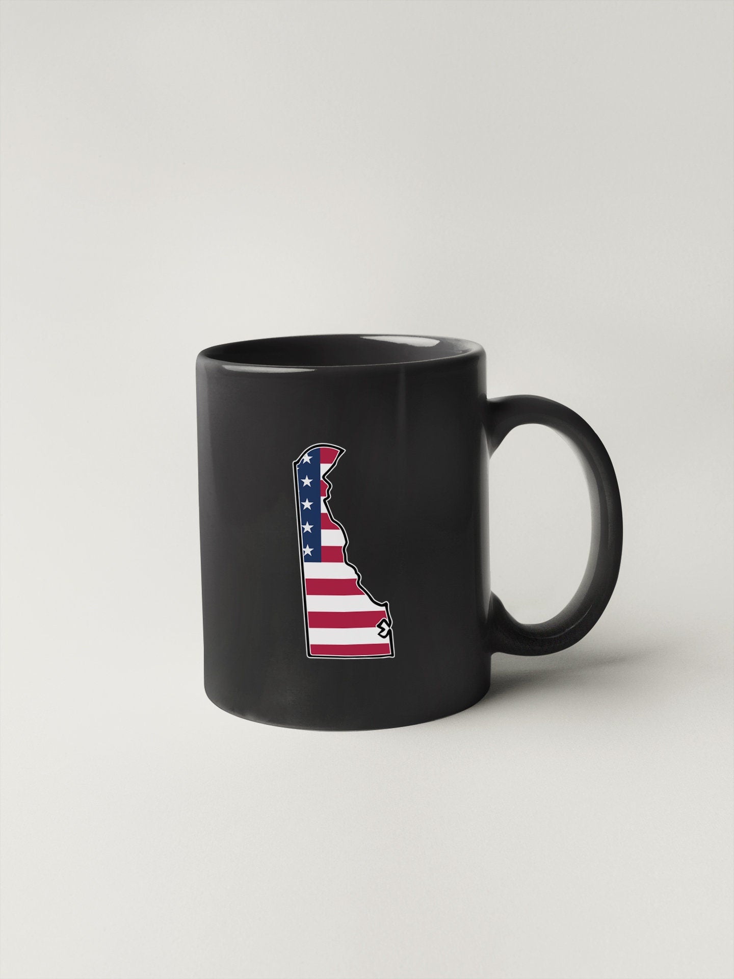 a black coffee mug with an american flag on it
