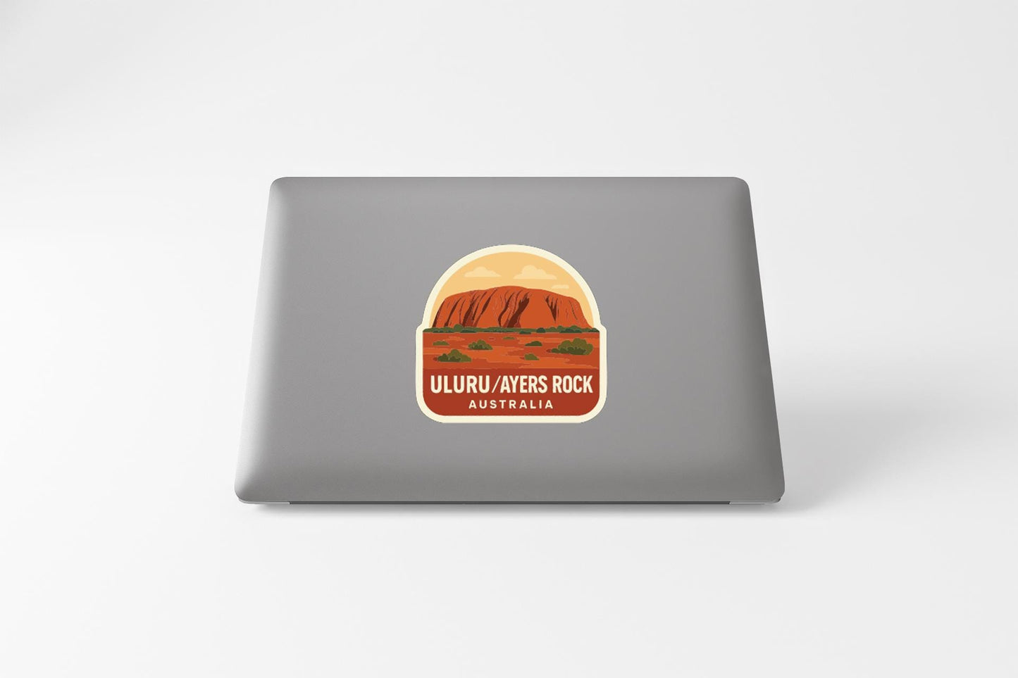 a sticker or decal of Uluru, a famous landmark in Australia, on the back of a laptop computer.