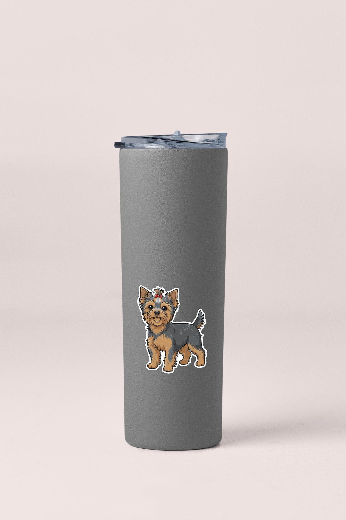 A gray insulated tumbler with a small cartoon illustration of a dog on it.