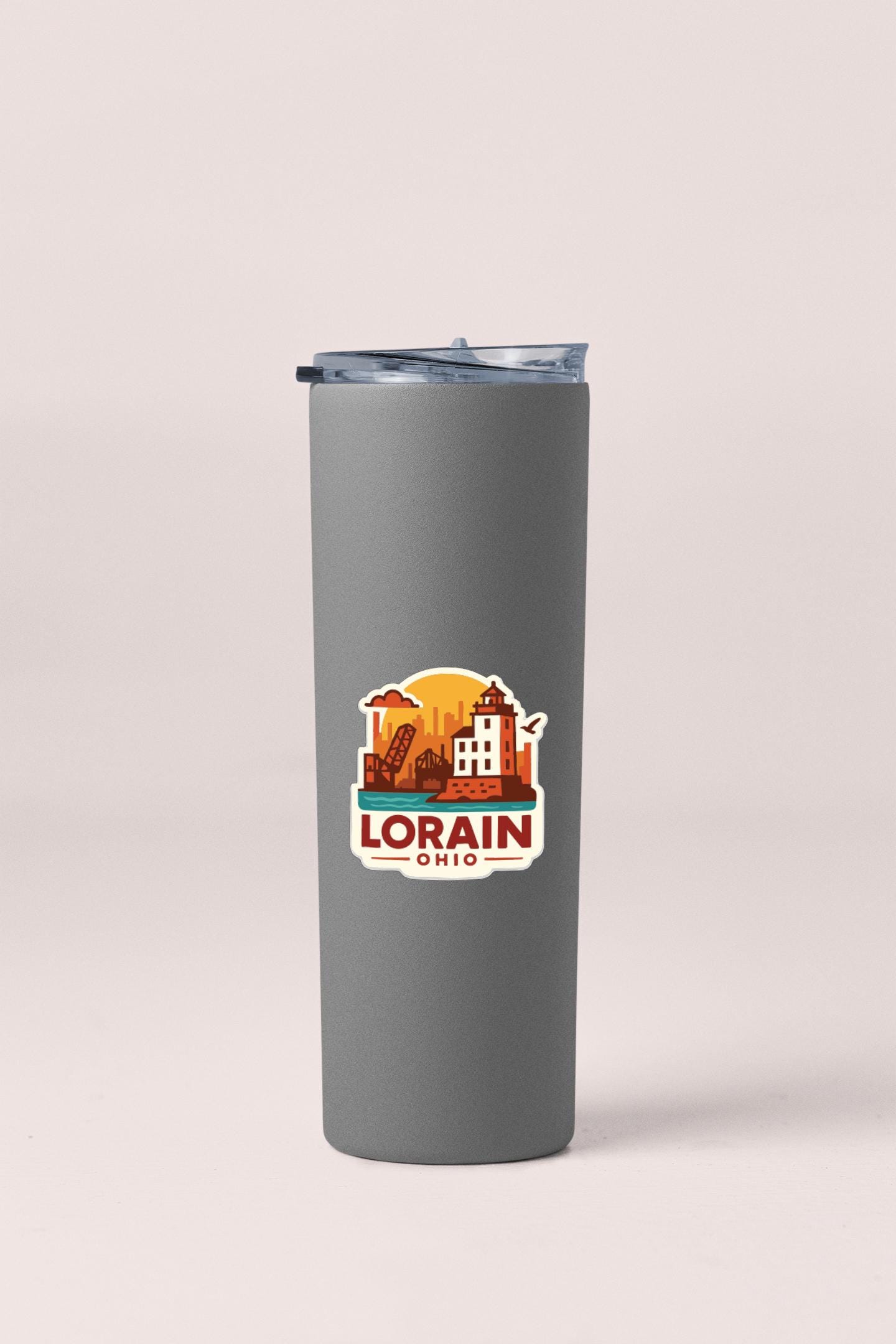 A gray insulated tumbler with a lid and a sticker featuring an illustration of a city skyline and the text "LORAIN, OHIO".