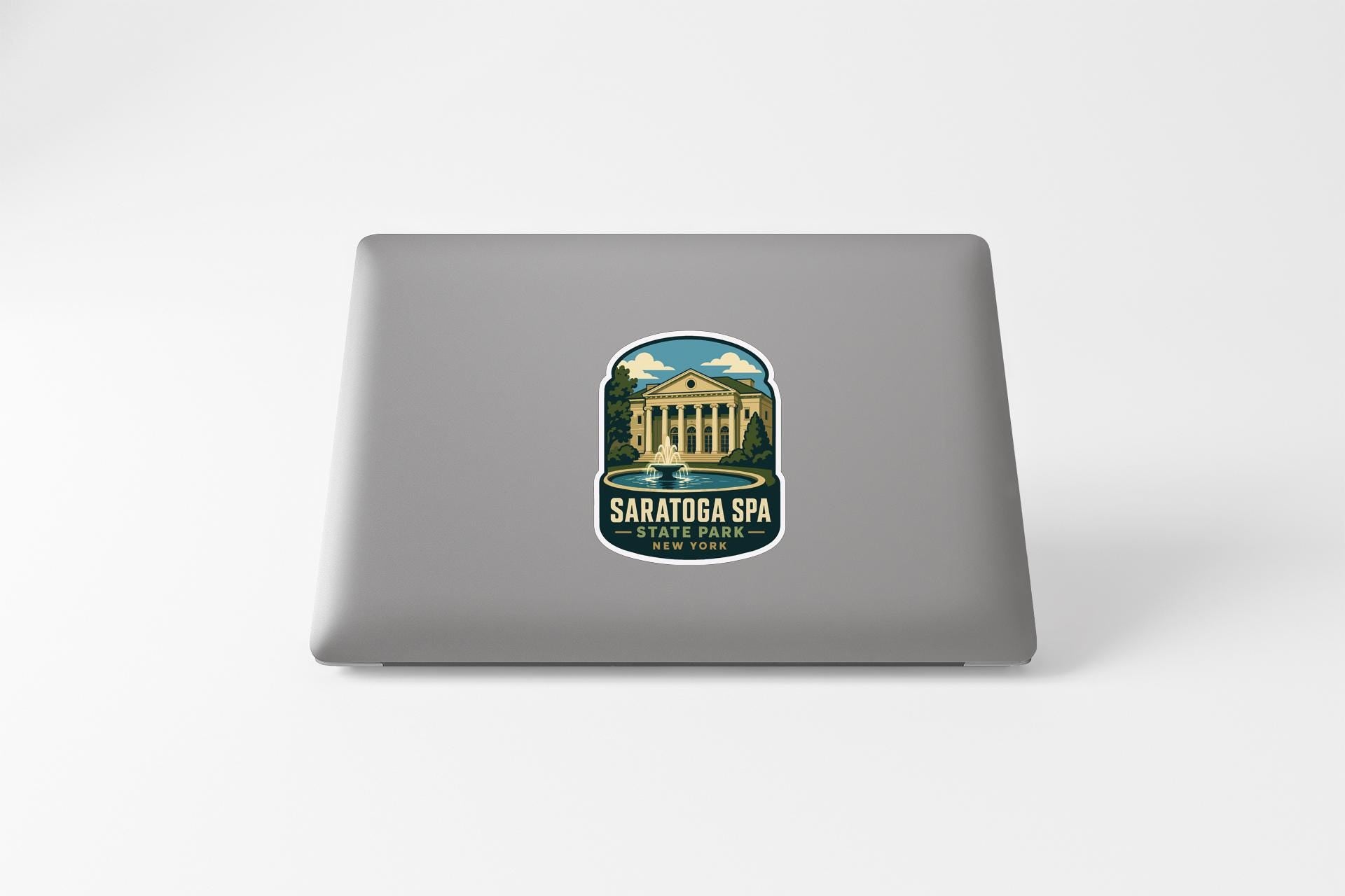 a sticker on the back of a laptop, depicting a building with columns and a fountain.