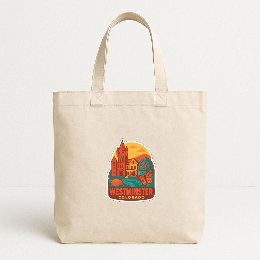 A beige tote bag with a colorful graphic depicting a cityscape and the text "Westminster, Colorado" printed on it.