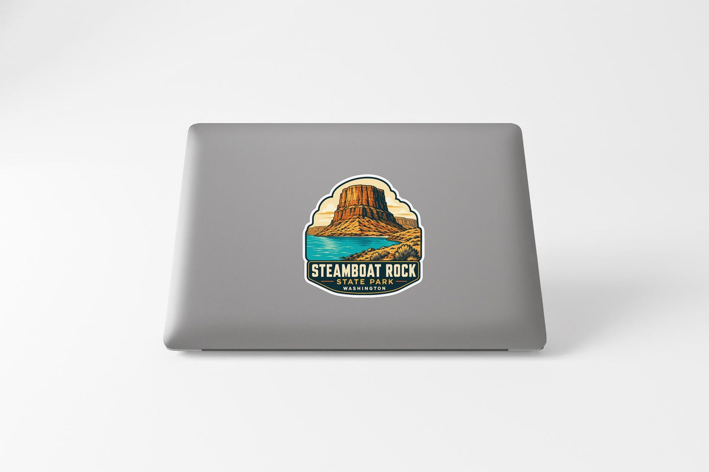a sticker or decal on the back of a laptop, depicting a scenic landscape with a mountain and a body of water.