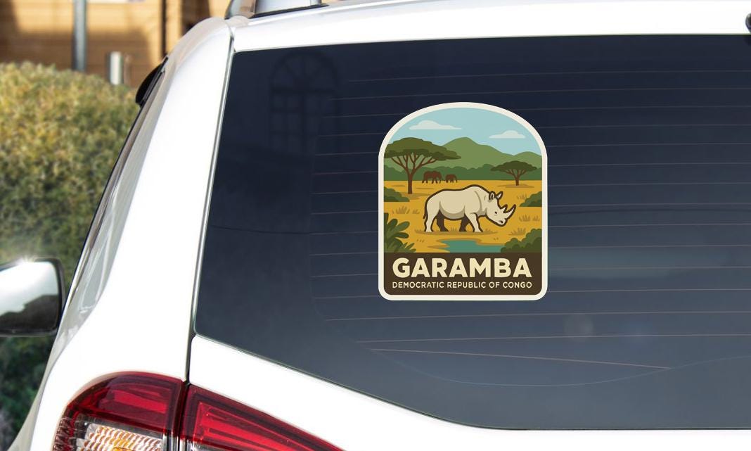 a sticker on the rear window of a car, depicting a rhinoceros in a natural landscape.